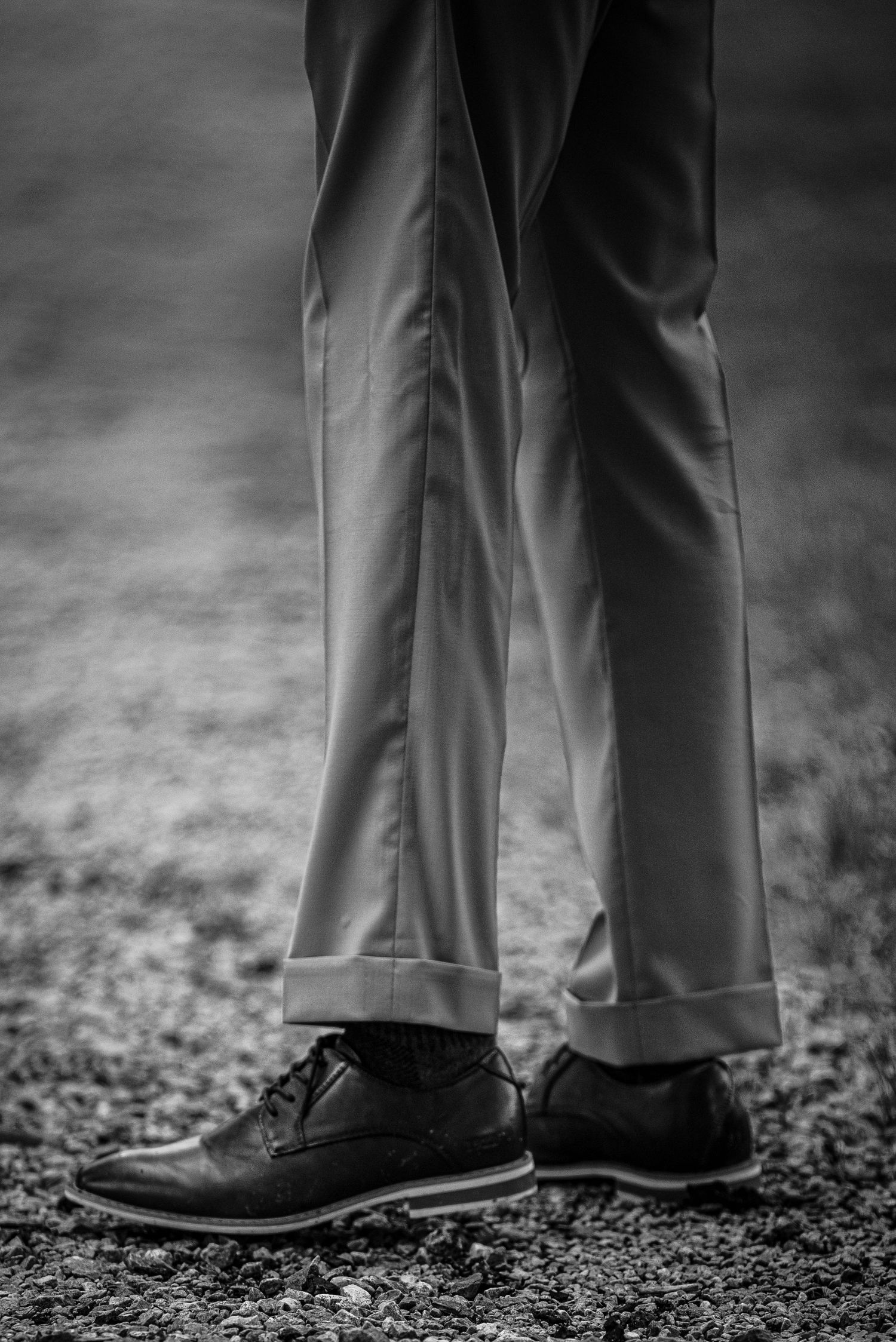 A closeup shot of Myles' suit pants and dress shoes before the ceremony. The photo is in black and white.