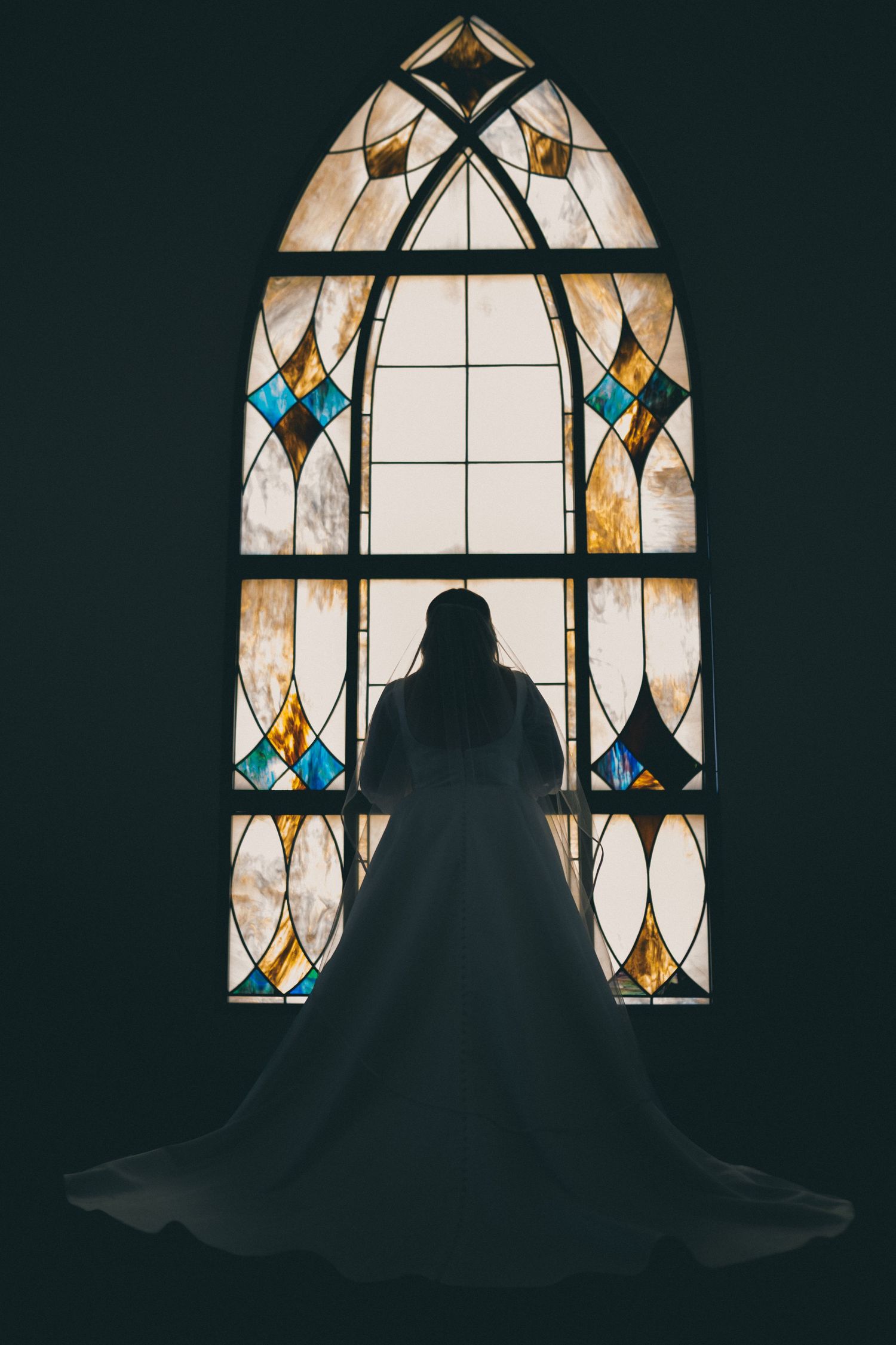 Bride Sally, looking out the dreamy stained glass window of the First Christian Church; picture taken standing in original church's doors.