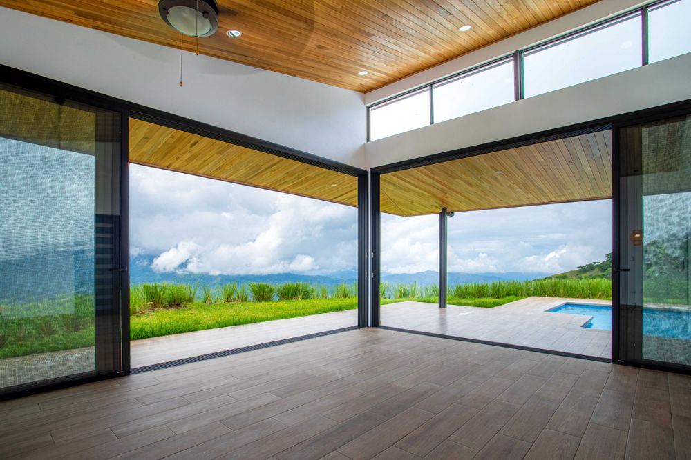Living area with floor-to-ceiling windows connecting to nature, offering an open and bright living experience in Atenas, Costa Rica