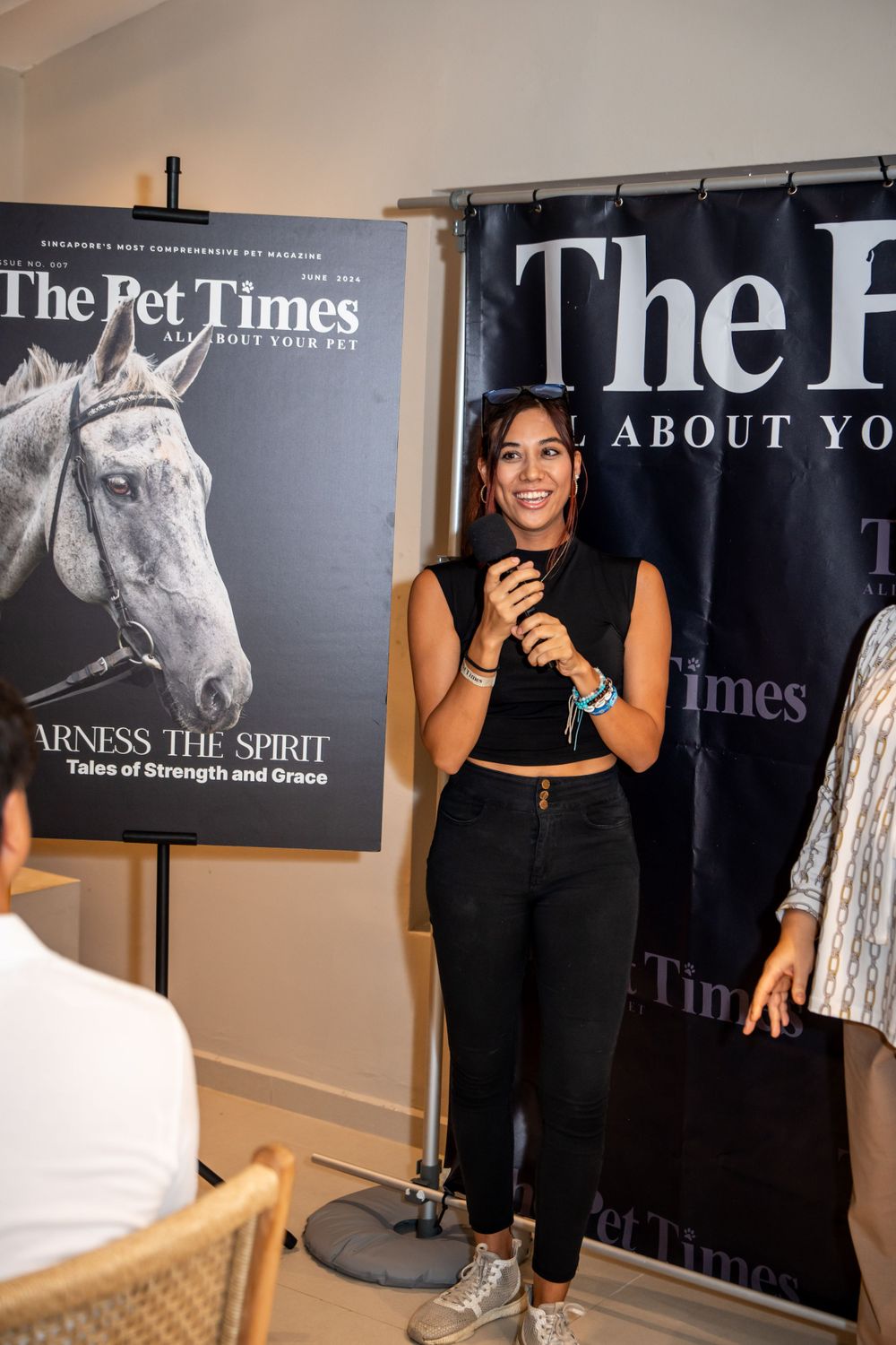 A presenter stands in front of The Pet Times display banners featuring a horse illustration at a media event.