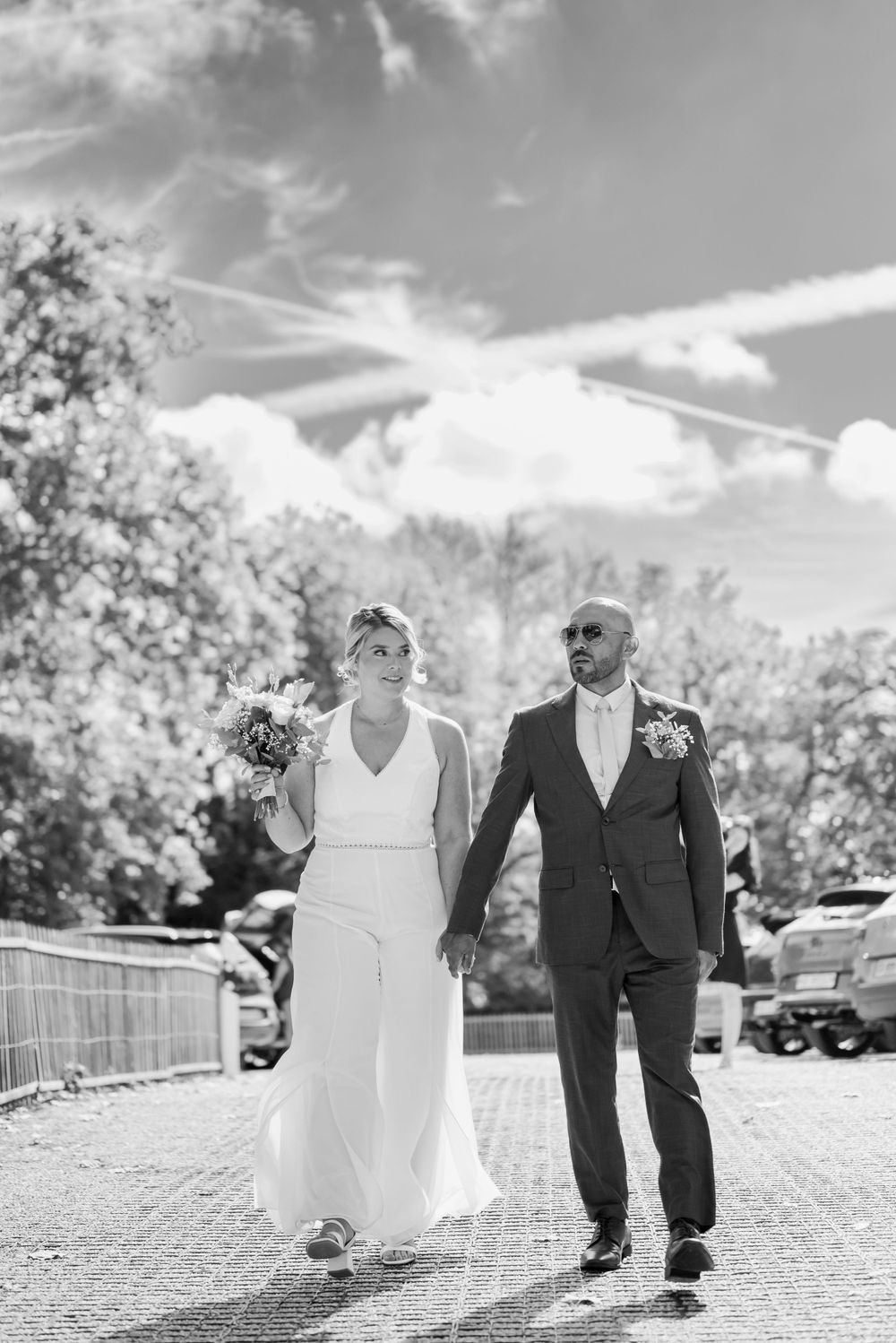 Couple walking towards their civil wedding dressed as groom and bride in a summer sunny day in Geneva, Switzerland