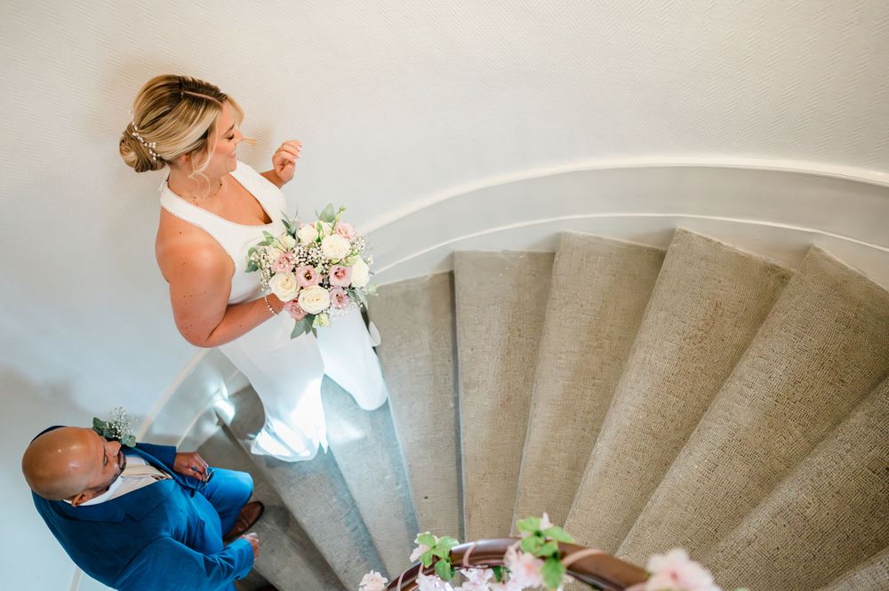 bride and groom walking up a spiral staircase at the Etat civil Chêne-Bougeries- Voirons in Geneva, Swtizerland