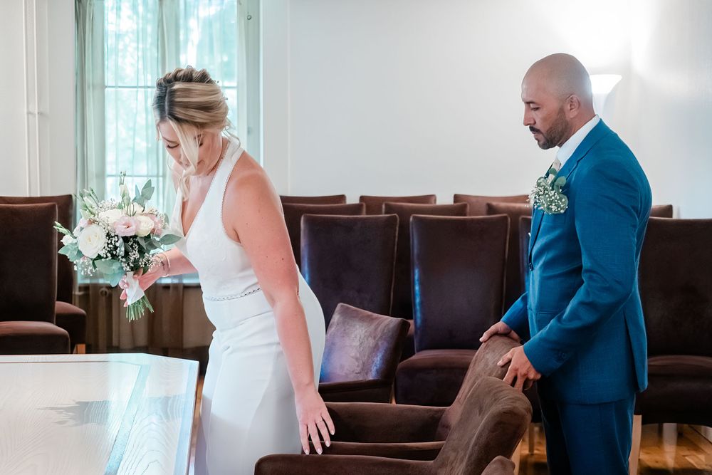 Groom is pulling up a chair in a kind gesture to his bride so she can sit just before the wedding in Geneva, Switzerland