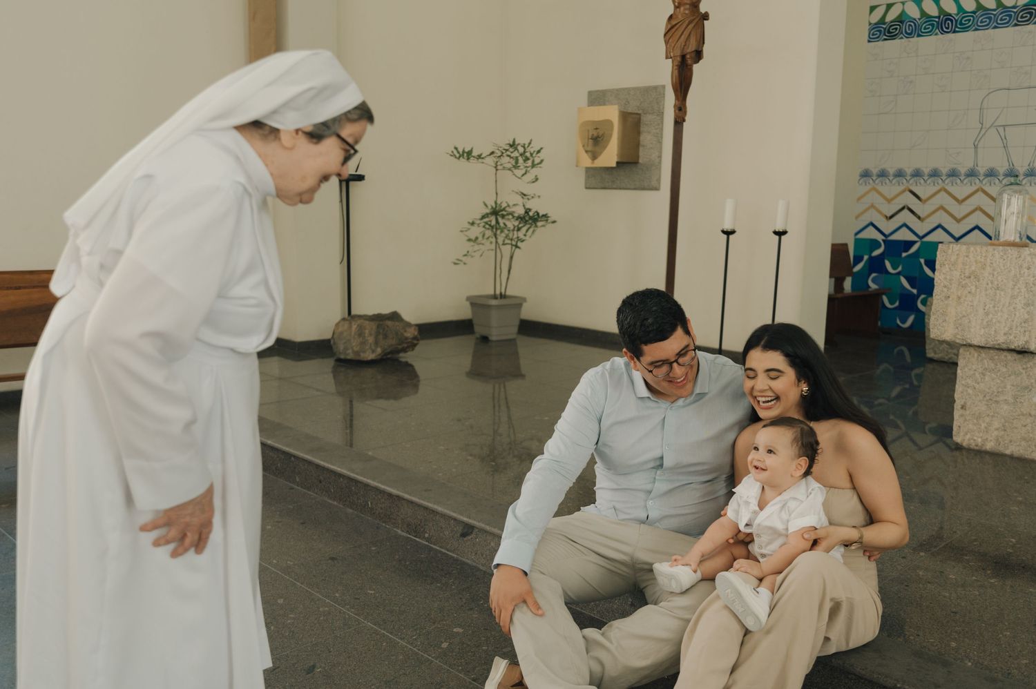 A religious figure in white habits meets with a small group in a modern church setting.