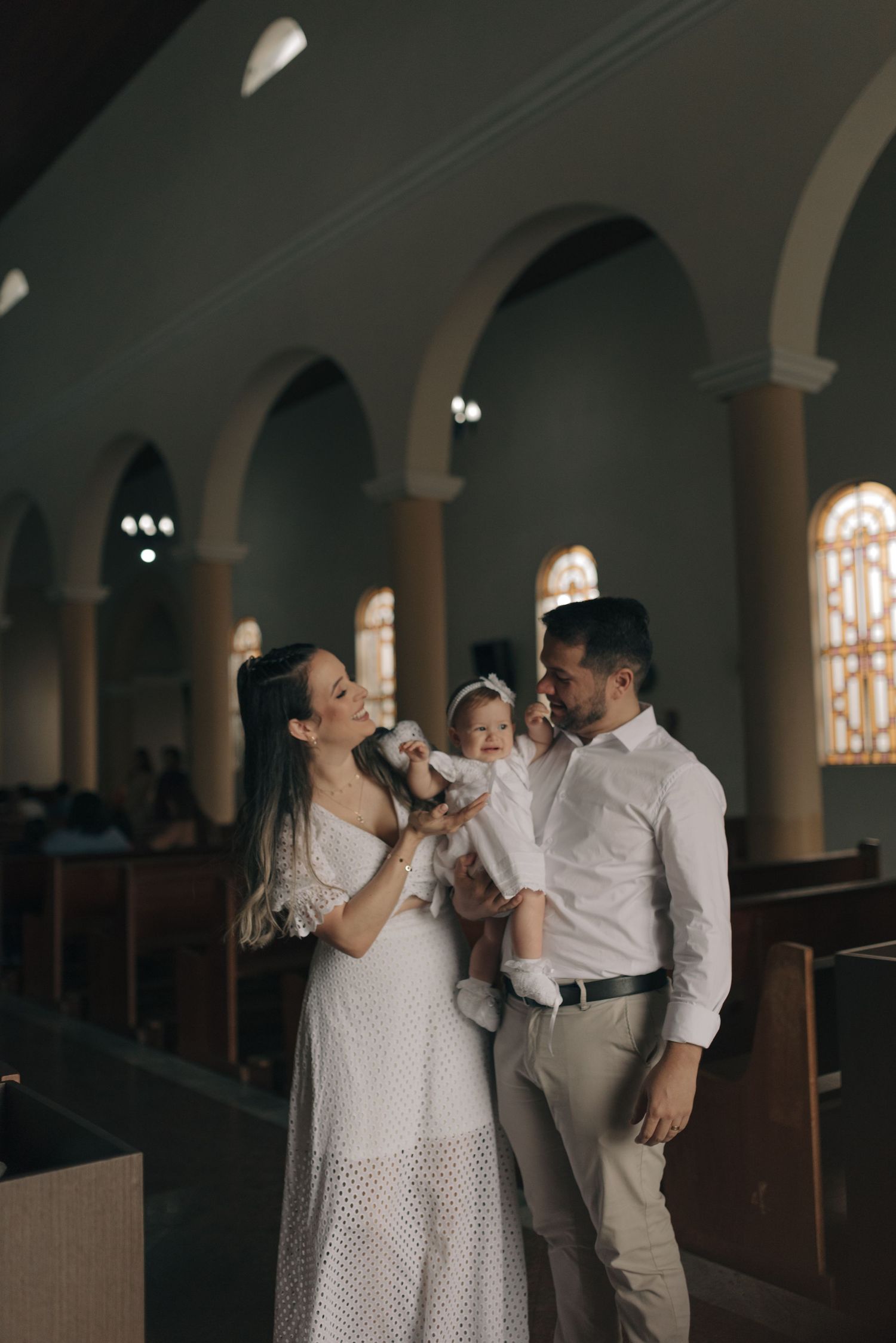 Family shares joyful moment inside church with arched architecture.