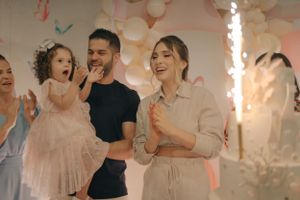 Celebratory moment with sparklers and pink decorations at an indoor party.