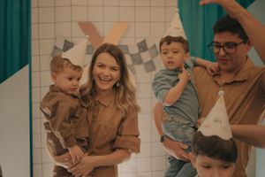 Family celebration with bunny-themed party decorations and checkered backdrop.