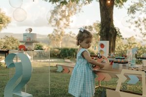 Turquoise and white color scheme outdoor garden party setting with paper lanterns and decorative elements at sunset.