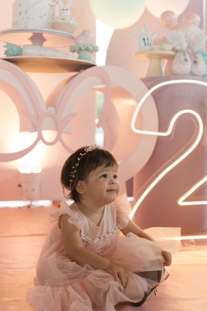 Pink tutu dress and number 2 decor create a dreamy birthday party setting with soft lighting and whimsical decorations.