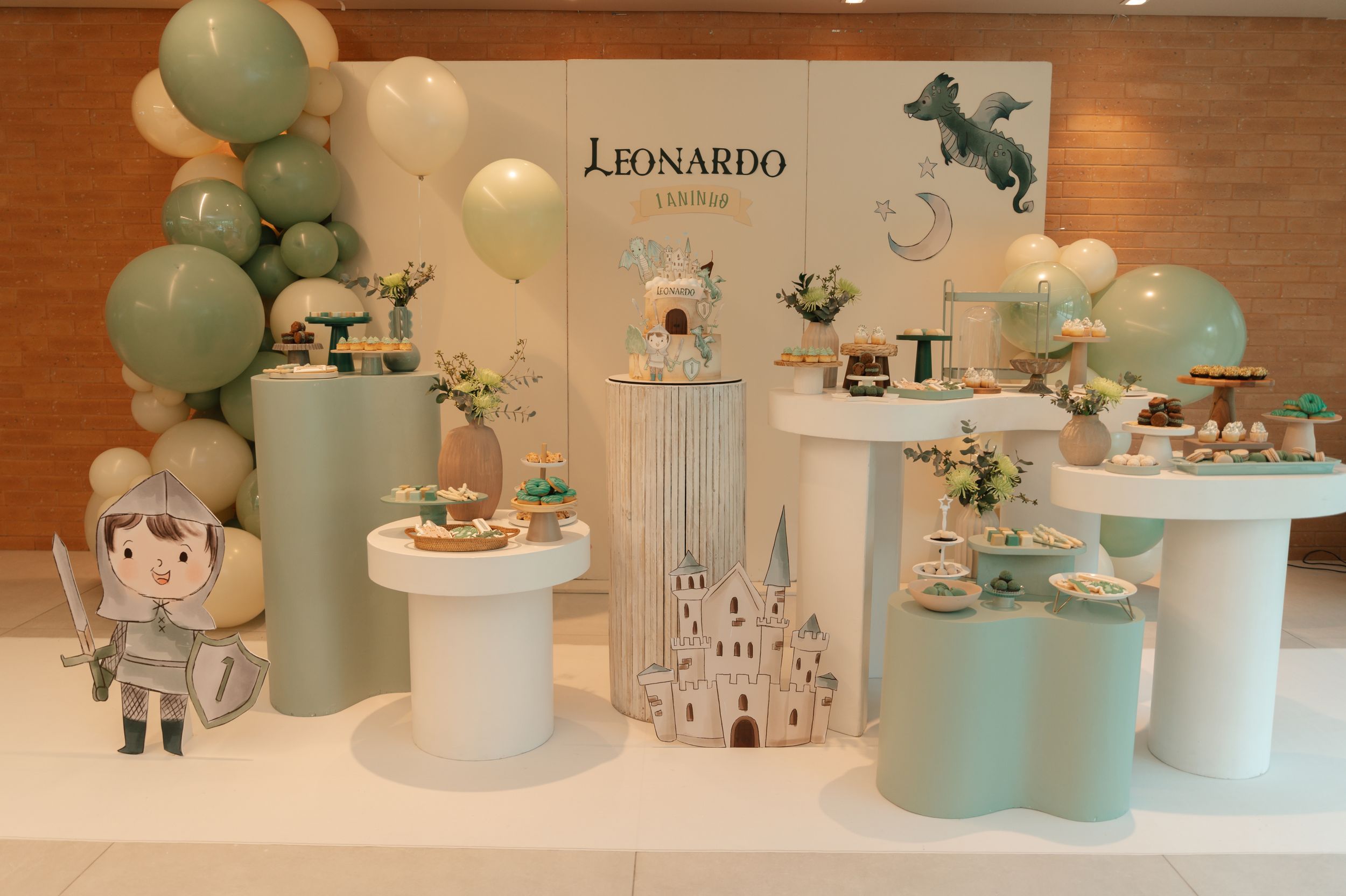 A collection of mint green ceramic teapots, vases and decorative items arranged on wooden display shelves against a white wall.