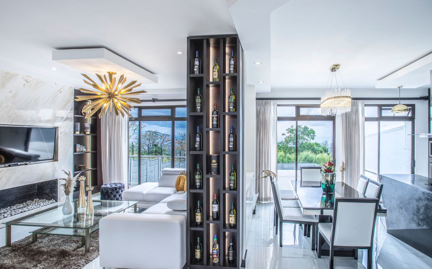 Luxurious dining and living area with elegant furniture, large windows offering natural light, and scenic views in a contemporary home in At