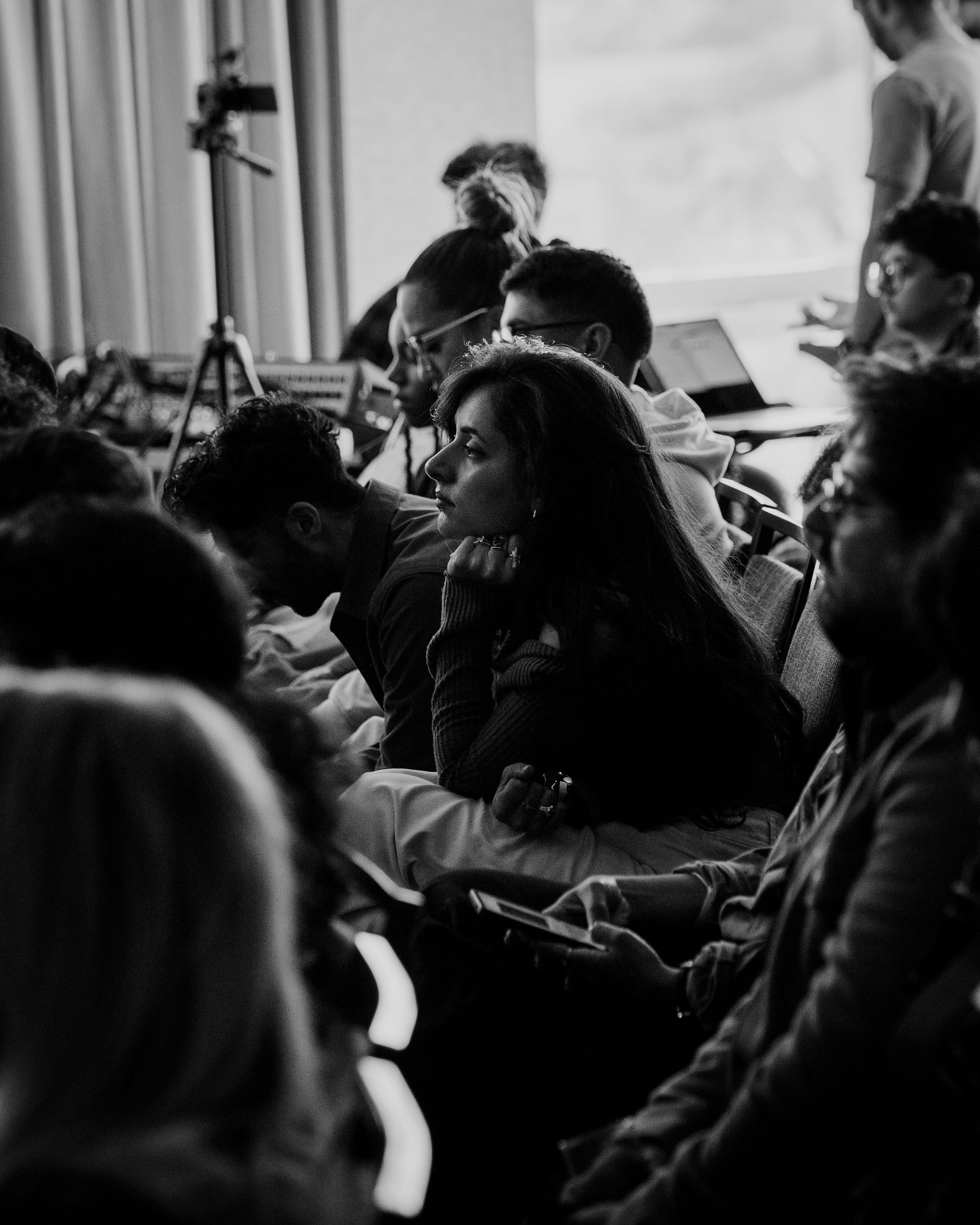 Black and white photo of audience members seated at an indoor event.