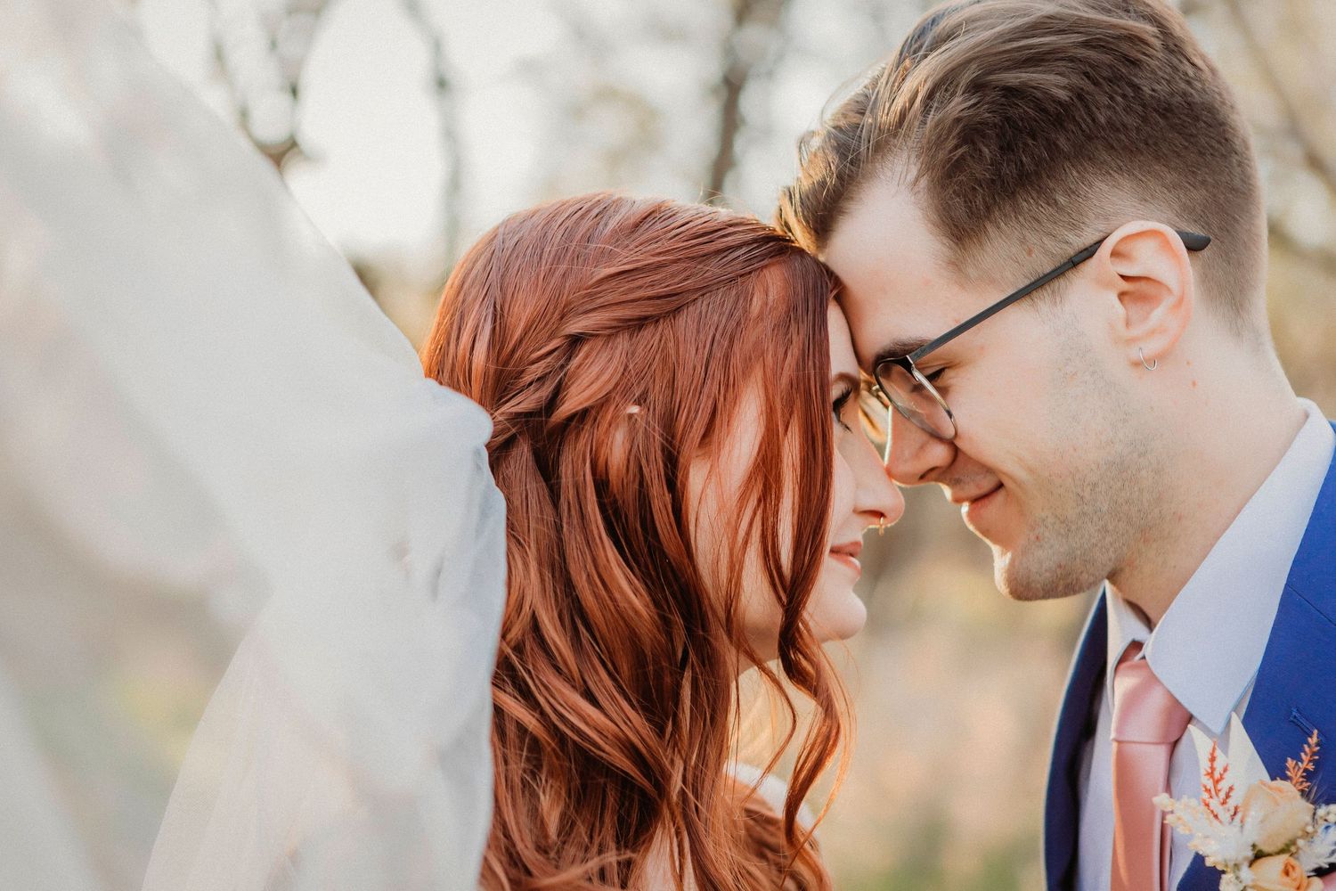 Romantic wedding portrait of couple in intimate moment outdoors.