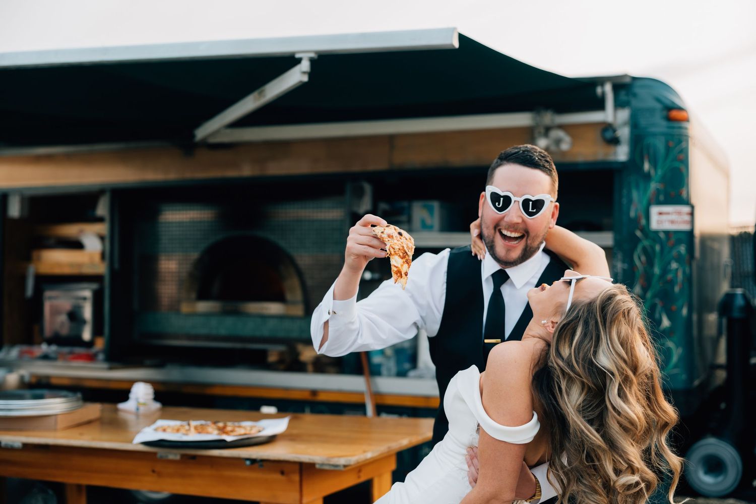 A couple walks into their Pitot House wedding reception through a rustic wooden fence in New Orleans, LA