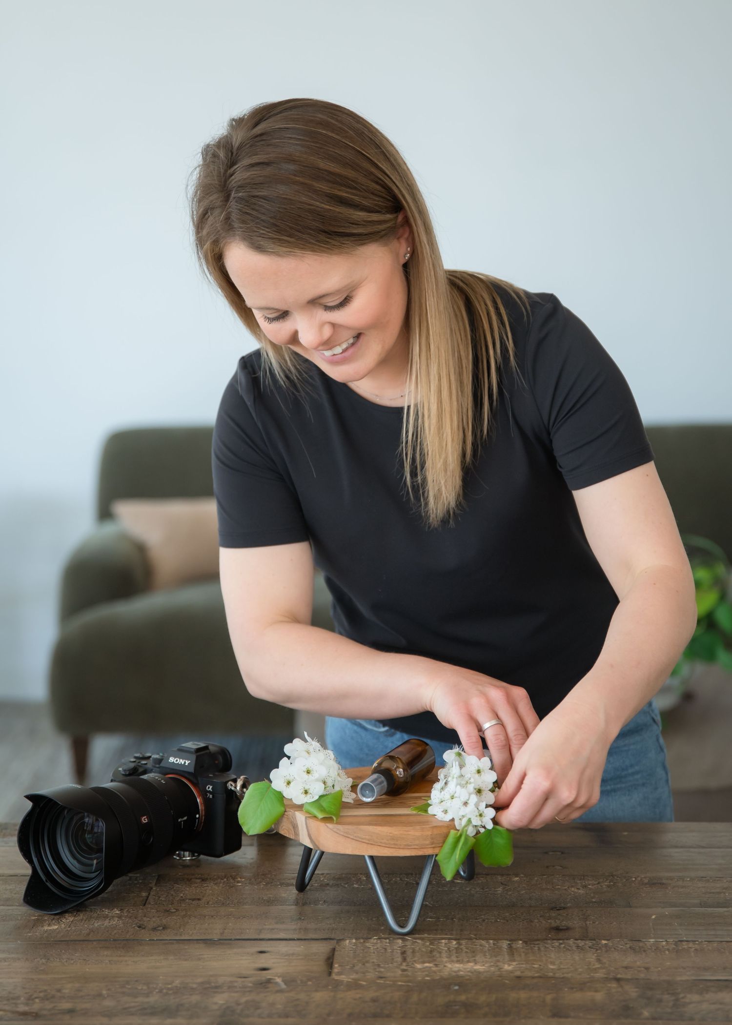 A photographer wearing black shirt and jeans holds a camera while interacting with a small child in matching denim.
