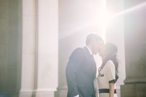 A romantic silhouette against bright sunlight streaming through white columns.