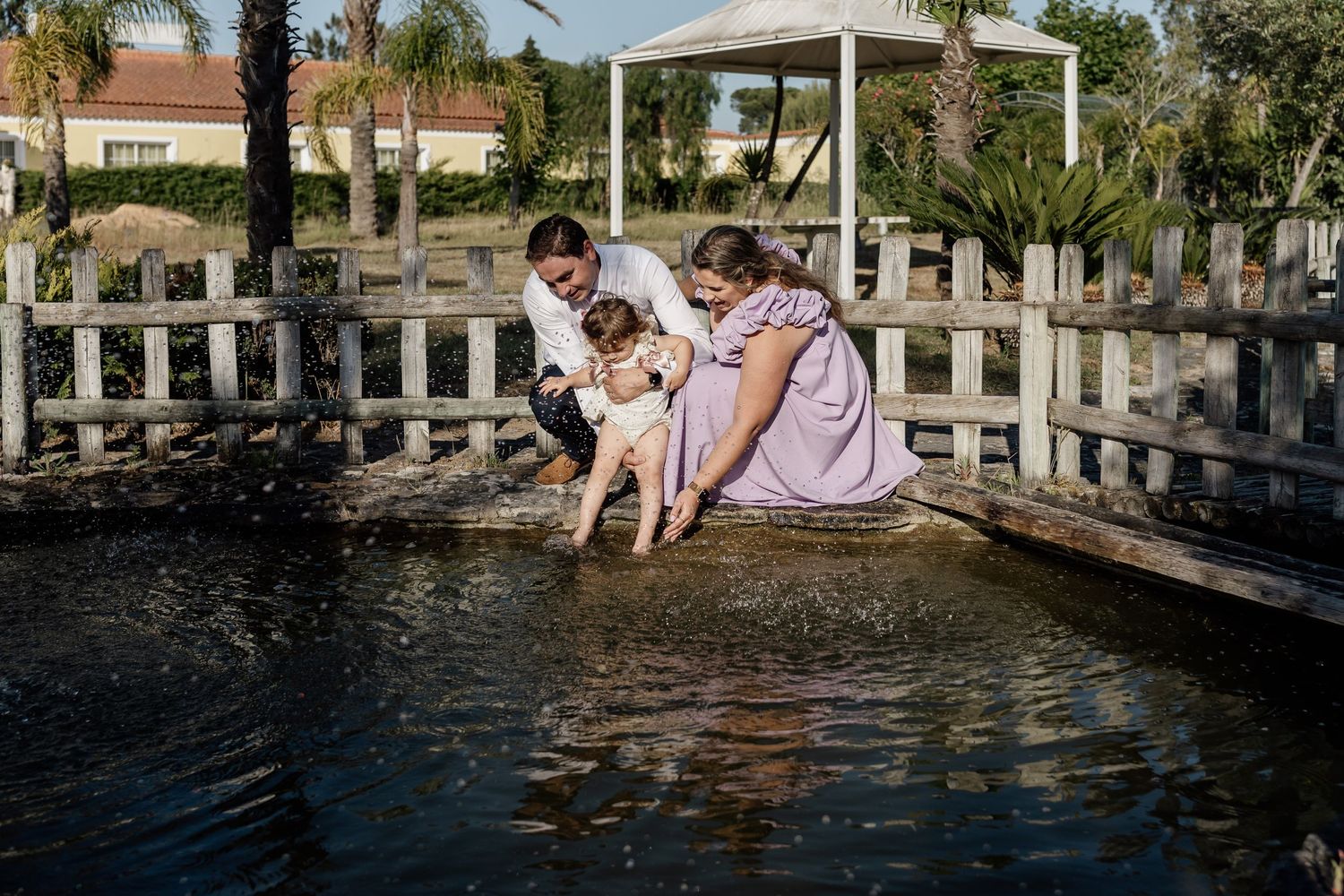 Family enjoying a fun moment together at a wooden dock by the water.