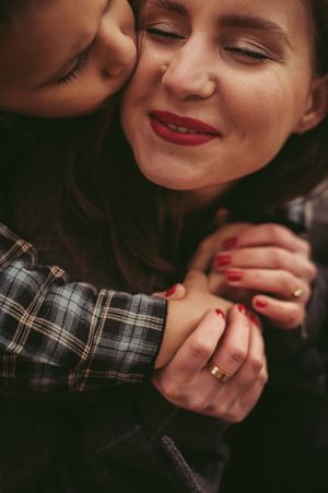 Cozy indoor family photo of mom and son sharing a cuddle
