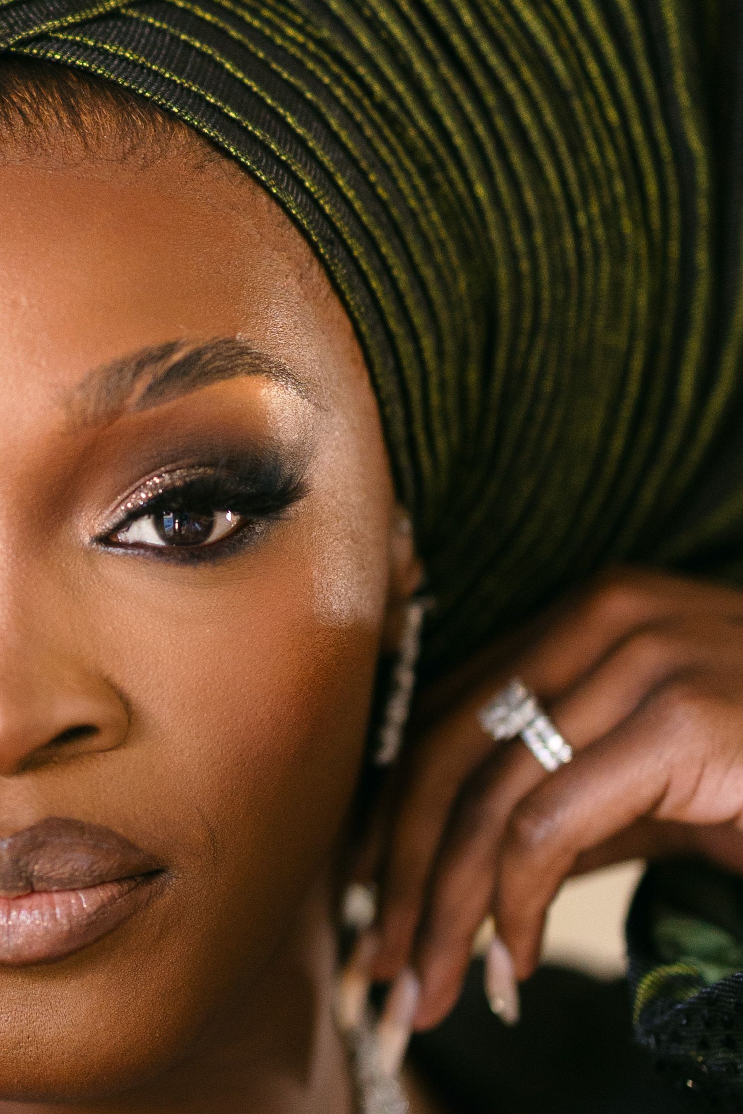 Close-up portrait sequence showing dark eyes with dramatic black winged eyeliner and green headwrap against neutral background.