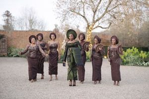 Wedding party poses outdoors wearing coordinating brown and green formal attire.