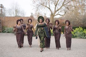 Group in coordinated outfits during a stylish outdoor photo shoot with brown and green attire.
