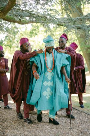 Traditional African celebration featuring contrasting turquoise and burgundy ceremonial attire.