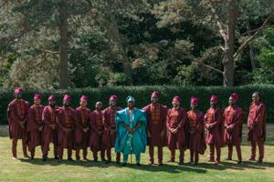 Choir members in burgundy robes pose for formal group photo with seated members in front.