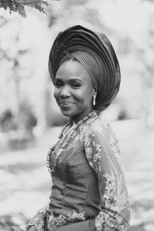 Black and white portrait showing traditional African formal attire and gele headwrap.