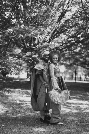 A vintage-style black and white photo of a couple in traditional African ceremonial attire.