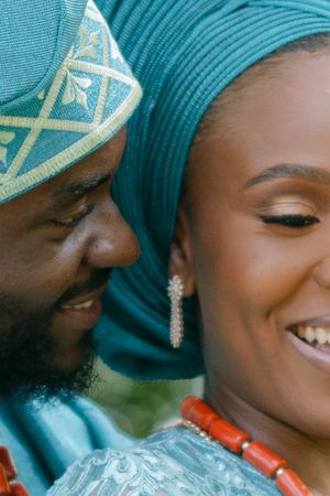 Close-up portrait of a couple in turquoise traditional Nigerian attire sharing an intimate moment.
