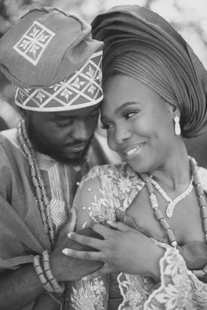Black and white intimate portrait of couple in traditional Nigerian wedding clothes.