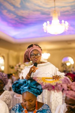 Traditional ceremony with chandelier and purple-lit ceiling in elegant venue.