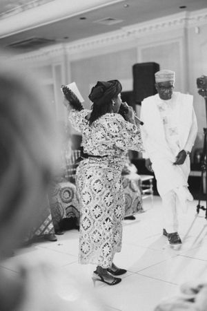 Traditional African celebration showing dancing in patterned clothing at an elegant indoor venue.