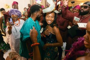 Wedding celebration with guests dancing and celebrating in colorful traditional African attire.