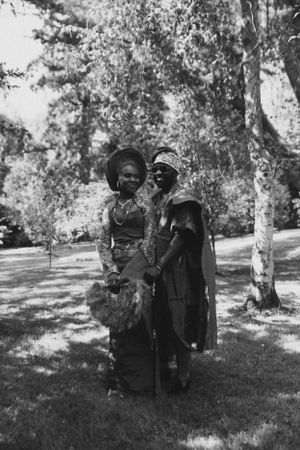 Vintage black and white photograph of couple in traditional dress standing outdoors.