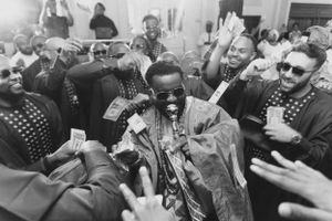 A black and white photo captures an energetic celebration with a crowd cheering.