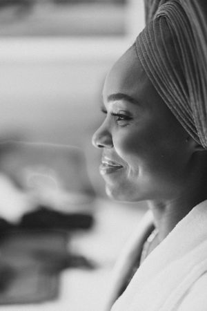 Side profile shot of person wearing traditional white headwrap in black and white.