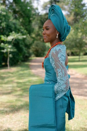 Side profile shot showcasing turquoise traditional attire with matching head wrap.