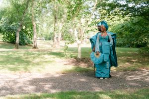 Full length view of traditional turquoise ensemble with matching accessories in woodland setting.