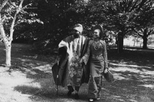 Vintage black and white photograph of people walking together through a park.