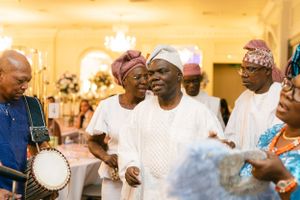 Musicians with traditional instruments perform at a joyous celebration in formal attire.