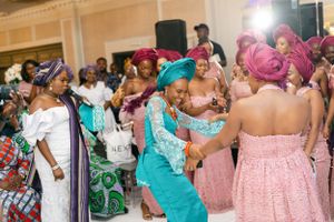 Joyful dancing and celebration at a formal event with guests in traditional African attire.