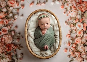 Six neutral-toned newborn photography portraits showcase a serene baby wrapped in sage green against a floral backdrop.