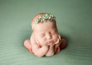 Composite of baby sleeping poses on green fabric wearing small flower crown in professional newborn photography session.