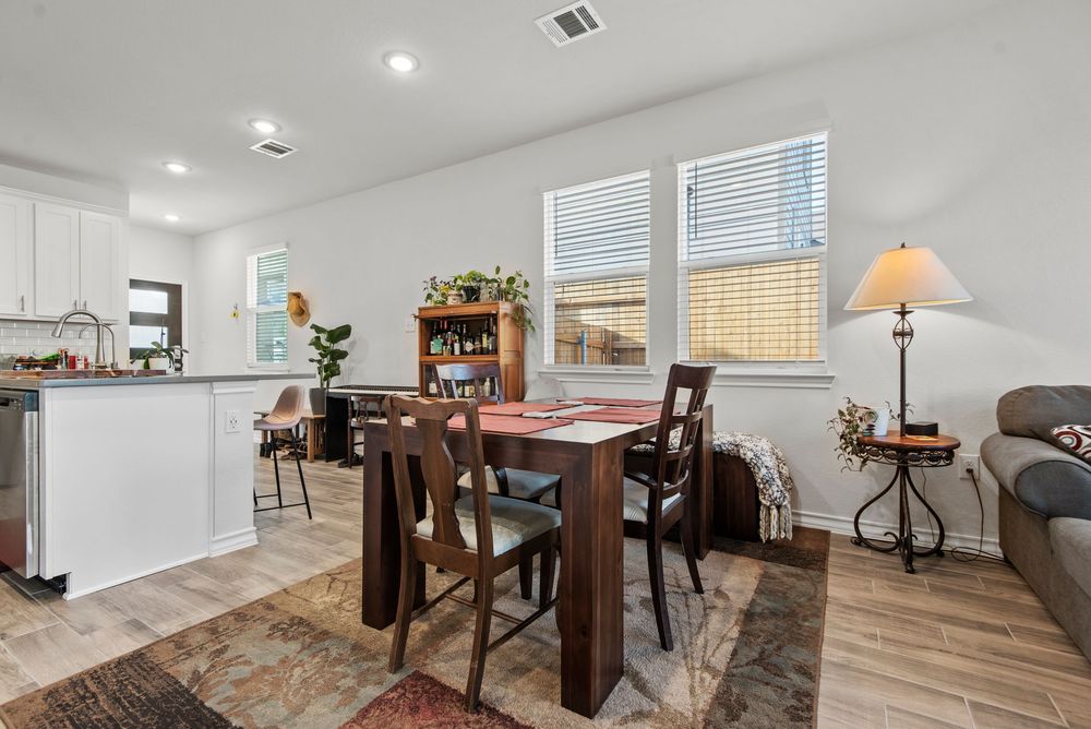 Modern basement living space with vinyl flooring, recessed lighting, and ample natural light from windows.