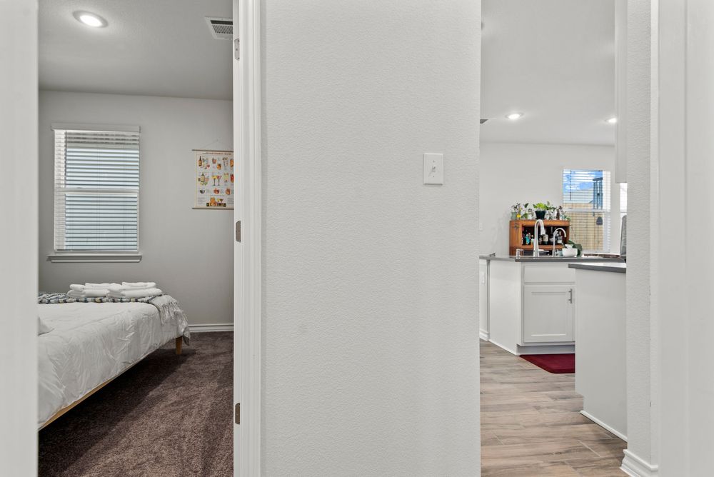 Newly renovated modern home interior featuring white walls and grey flooring in a brightly lit hallway.