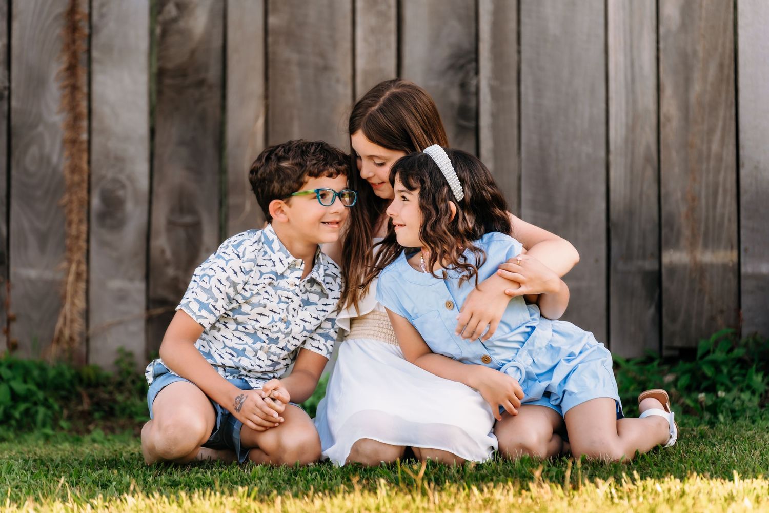 Couple relaxing together on wooden deck in backyard wearing coordinated blue and white outfits.