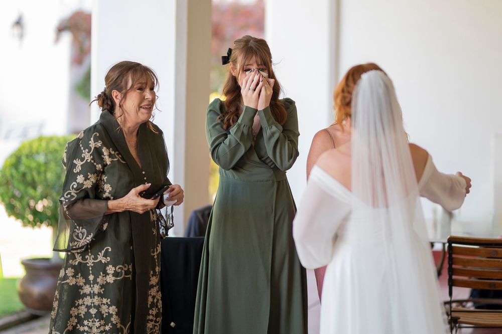 Emotional reactions during a wedding reveal moment with guests in formal attire.