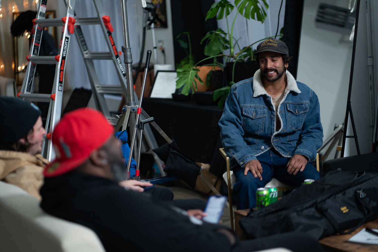 Behind-the-scenes photo of film production with crew and lighting equipment in studio setting.