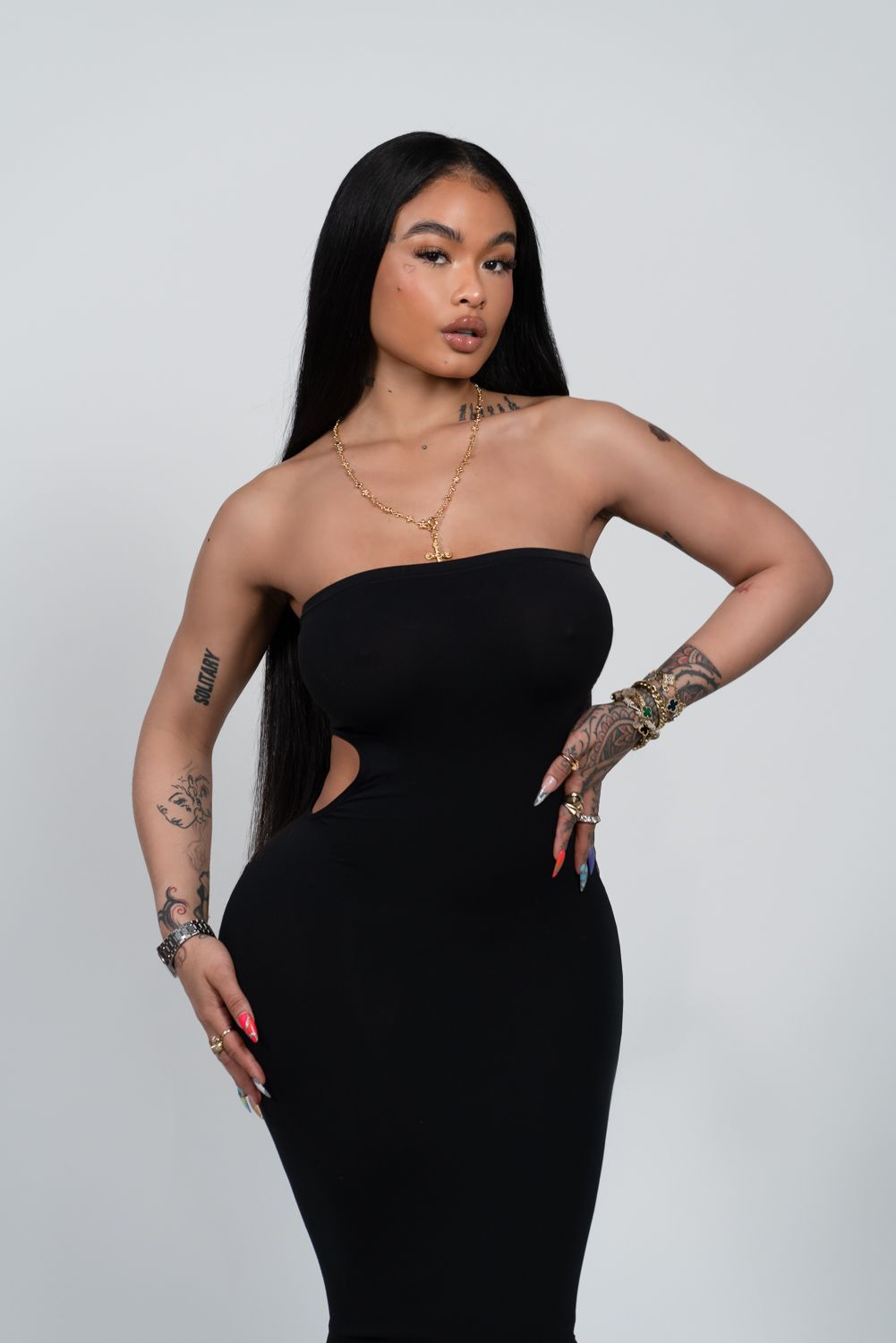 Studio fashion portraits of a model in a black strapless dress posing confidently against a white backdrop.